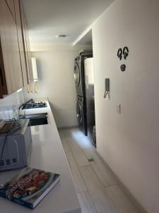 uma pequena cozinha com um frigorífico e um fogão em Acogedor apartamento en zona corporativa Ciudad Salitre em Bogotá