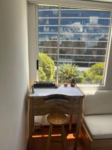 a desk in front of a window with a keyboard at Acogedor apartamento en zona corporativa Ciudad Salitre in Bogotá