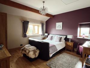 1 dormitorio con cama y lámpara de araña en Weather Hill Cottage, Hebden Bridge, en Hebden Bridge