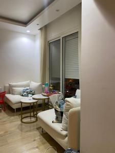 a living room with couches and tables and a window at Al rehab city-new cairo in New cairo