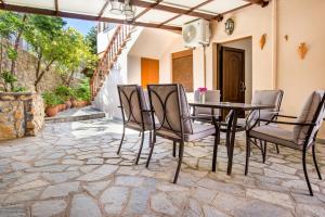 a patio with a table and chairs on a stone floor at Studios TOUTOULA in Skala Marion