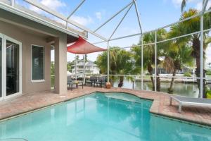 a swimming pool in front of a house at Manatee Manor in Marco Island