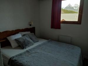 - une chambre avec un grand lit et une fenêtre dans l'établissement Bel appartement 4 à 6 personnes à 1800, à Puy-Saint-Vincent