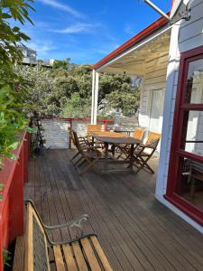 una terraza de madera con mesa y sillas. en Hilltop on Milton, en Napier