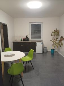 a kitchen with a table and green chairs in a room at Apartmány u golfu in Jihlava