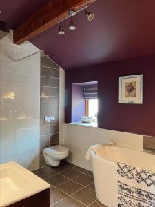 a bathroom with a tub and a toilet and a sink at Weather Hill Cottage, Hebden Bridge in Hebden Bridge