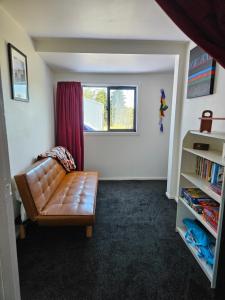 a living room with a couch and a window at Marg's on the Corner in Kumara