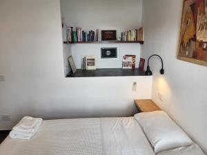 um quarto com uma cama e uma prateleira com livros em La BouganVilla em Portovenere
