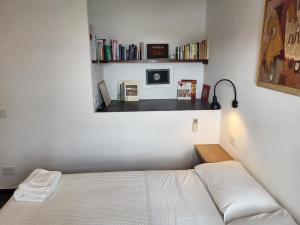sypialnia z łóżkiem i półką z książkami w obiekcie La BouganVilla w mieście Portovenere
