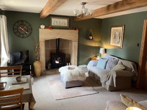 sala de estar con sofá y chimenea en Weather Hill Cottage, Hebden Bridge, en Hebden Bridge