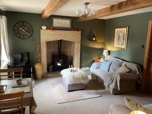 a living room with a couch and a fireplace at Weather Hill Cottage, Hebden Bridge in Hebden Bridge