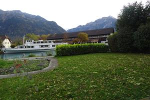 un barco en un río junto a una casa en Aare Studio 1 en Interlaken