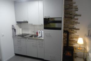 a small kitchen with white cabinets and a stove at Aare Studio 1 in Interlaken