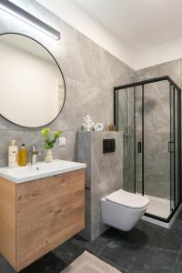 a bathroom with a shower and a toilet and a sink at Platinum Apartments in Warsaw