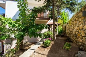 a garden with a stone wall and a building at Studios TOUTOULA in Skala Marion +20 photos