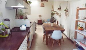 a kitchen with a wooden table and a dining room at La Puerta Azul in Tandil