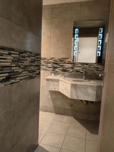 La salle de bains est pourvue d'un lavabo et d'un miroir. dans l'établissement فندق دان البلاتيني, à Médine