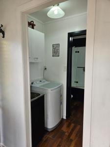 a small kitchen with a sink and a stove at Marg's on the Corner in Kumara +63 photos