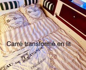 a bed with the words care transformine an it at Séjour unique à bord d un voilier in La Rochelle