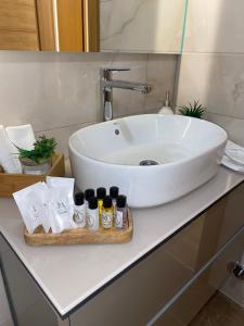 La salle de bains est pourvue d'un lavabo blanc et de serviettes. dans l'établissement Miyaki Apartments - BJELASNICA, à Bjelašnica