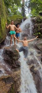 drie mannen op een waterval bij Cabaña la Hamaca Grande un encuentro con la naturaleza in El Zaino