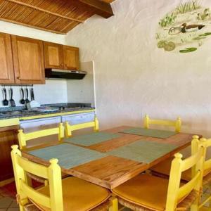 a kitchen with a wooden table with chairs around it at Seaside apartment Baja Sardinia - 6pl July - 150 m from smeraldo beach in Baja Sardinia