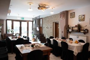 uma sala de jantar com mesas, cadeiras e janelas em Acetaia Malagoli Daniele e B&B em Castelfranco Emilia