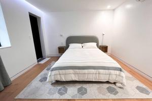 Dormitorio blanco con cama con manta en New Cozy Modern Minimalist Stay in Brooklyn at Rem-Casa, en Brooklyn