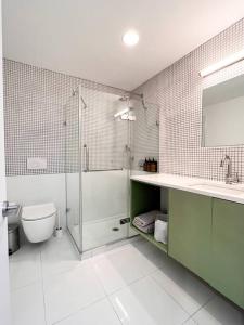 uma casa de banho com um chuveiro, um WC e um lavatório. em New Cozy Modern Minimalist Stay in Brooklyn at Rem-Casa em Brooklyn