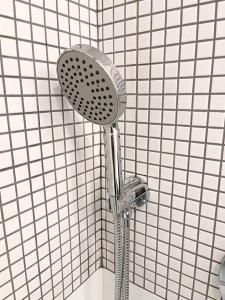 a shower with a shower head in a bathroom at New Cozy Modern Minimalist Stay in Brooklyn at Rem-Casa in Brooklyn