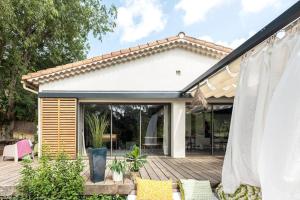 a home with a deck and a patio at La Coursive : belle maison de standing avec piscine in Montpellier