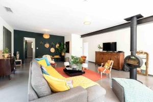 ein Wohnzimmer mit einem Sofa und einem Kamin in der Unterkunft La Coursive : belle maison de standing avec piscine in Montpellier