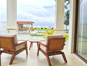 Aryan Beach Villa في وادوا: غرفة معيشة مع كرسيين وطاولة وفناء