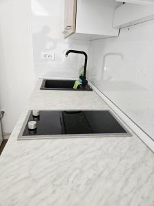 ein Waschbecken in einer weißen Arbeitsplatte in einer Küche in der Unterkunft Apartman Snowhite Bjelasnica in Bjelašnica