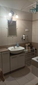 W łazience znajduje się umywalka, lustro i wanna. w obiekcie CAPPUCCINO CENTRUM Apartman w mieście Kaposvár