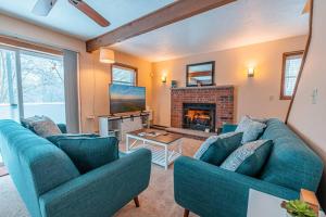 a living room with two blue couches and a fireplace at PoconoChalet-Hot Tub-Grill-Firepit-Games in Long Pond