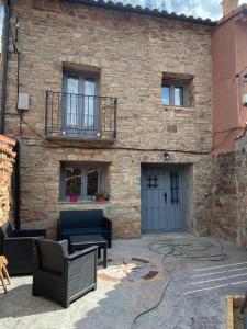 een stenen huis met een patio en een gebouw bij La Casa Rural de Pálmaces in Pálmaces de Jadraque