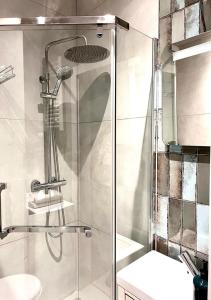 a shower with a glass door in a bathroom at George Studio przy Stadionie Narodowym in Warsaw