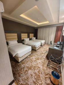 una habitación de hotel con 2 camas y una mesa y una habitación con 2 en فندق دان البلاتيني, en Medina