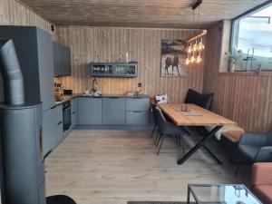 リューカンにあるFin leilighet med flott utsikt til Gaustatoppenの木製のテーブルと椅子のあるキッチンとダイニングルーム