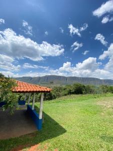 een bank in een veld met bergen op de achtergrond bij Pousada Nikimba in São Roque de Minas