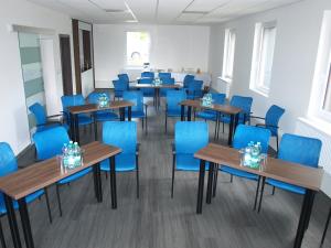 a room with blue chairs and tables and blue chairs at Apartmány u golfu in Jihlava