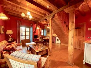 una gran sala de estar con paredes rojas y techos de madera. en El Encanto De Miraflores en Miraflores de la Sierra