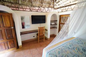 a bedroom with a bed and a flat screen tv at Hotel Mariposa in León