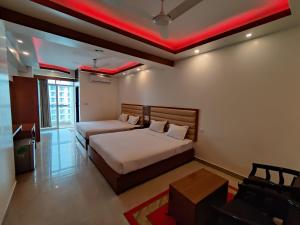 Hotel Sea Moon في كوكس بازار: غرفة نوم بسريرين واضاءة حمراء