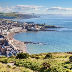 a view of a beach with a city and the ocean at Swn Y Mor 4 Aberystwyth in Aberystwyth +8 photos