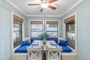 uma mesa de jantar com almofadas azuis e uma ventoinha de tecto em Lakefront retreat, hot tub, pets em Mabank