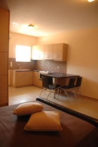 eine Küche mit einem Tisch und Stühlen im Zimmer in der Unterkunft Zeis Edo Luxury Apartments in Tolo