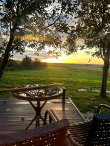 una mesa y sillas en una terraza con vistas a un campo en Woody en Szigetvár