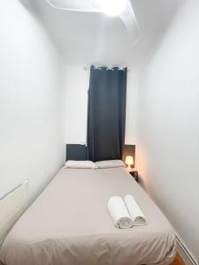 um quarto com uma cama com duas toalhas em Toledo habitaciones em Madri